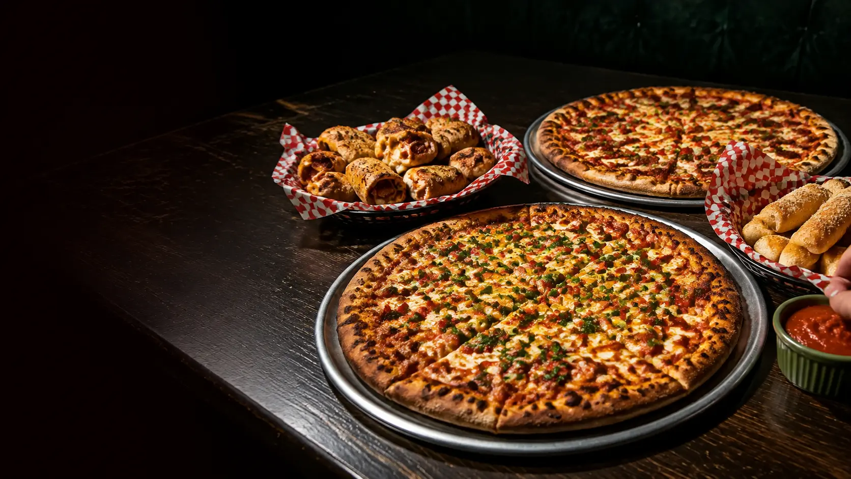 Pizzas, pizza rolls, and breadsticks arranged for a group meal